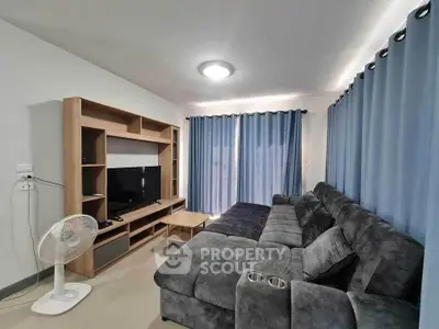 Spacious living room with modern furniture and entertainment center.