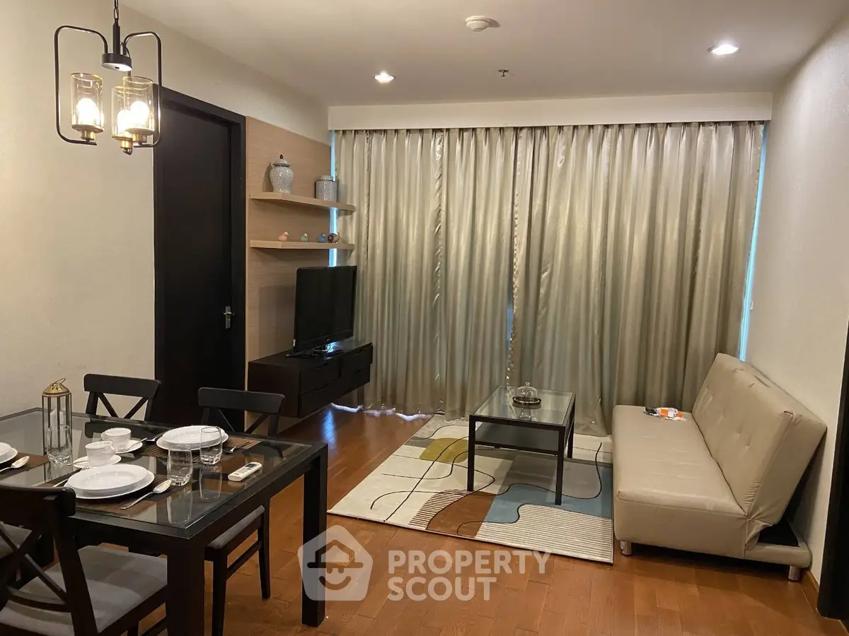Modern living room with dining area, stylish furniture, and elegant lighting in a cozy apartment.