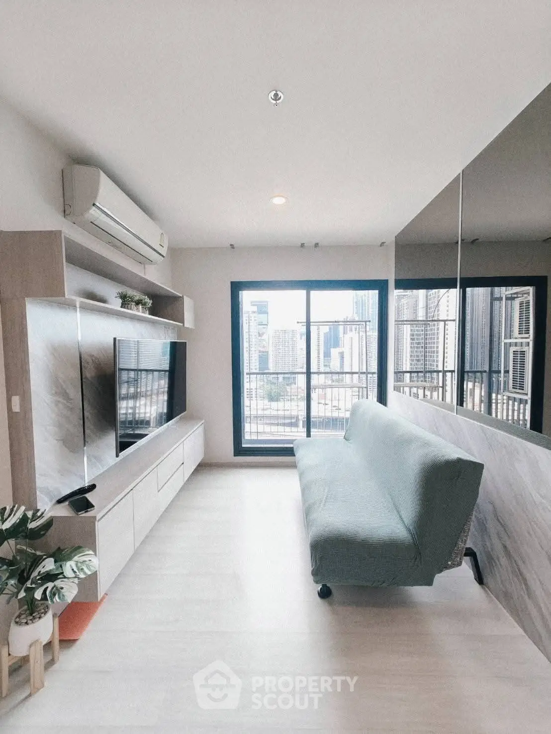 Modern living room with city view, sleek furniture, and large windows in urban apartment.