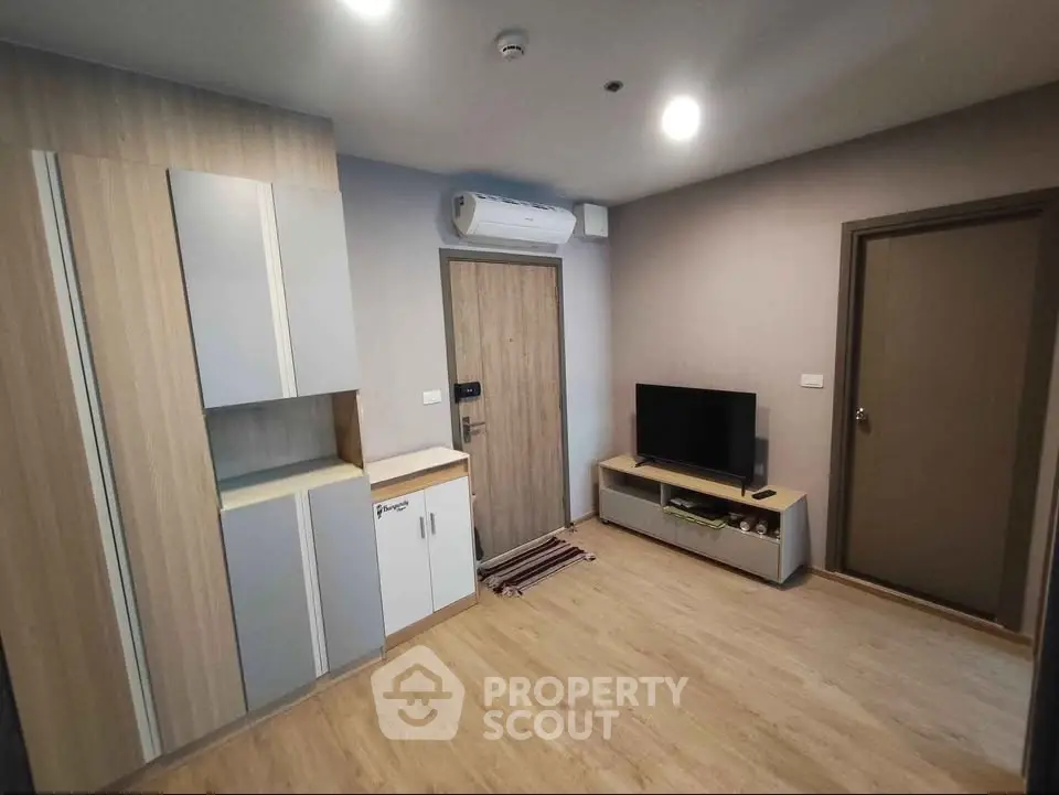 Modern living room with sleek wooden flooring and compact entertainment setup