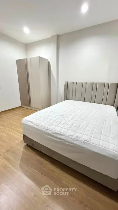 Spacious bedroom with modern design and elegant furnishings, featuring a large bed and sleek wardrobe.