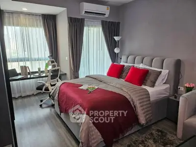 Modern bedroom with stylish decor and workspace, featuring large windows and elegant furnishings.