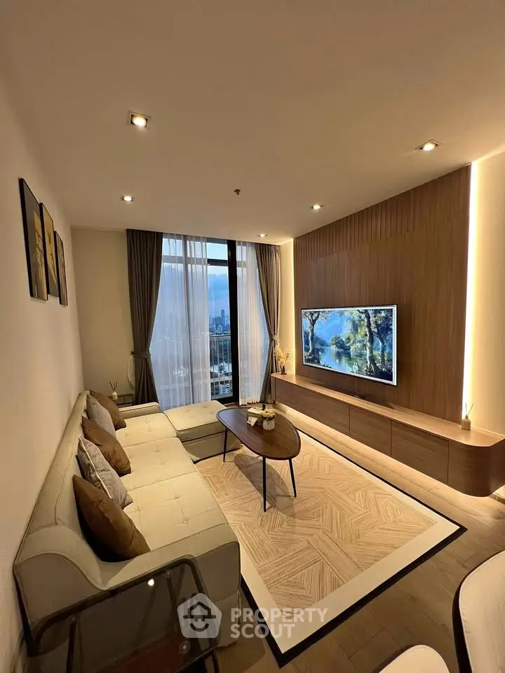 Modern living room with elegant decor and city view, featuring a cozy sofa and stylish TV setup.