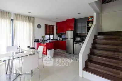 Modern kitchen with red cabinets and dining area in open layout design
