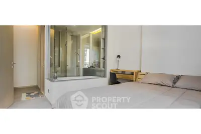 Modern bedroom with integrated glass shower and cozy workspace