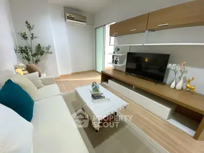 Modern living room with stylish furniture and flat-screen TV, perfect for relaxation.