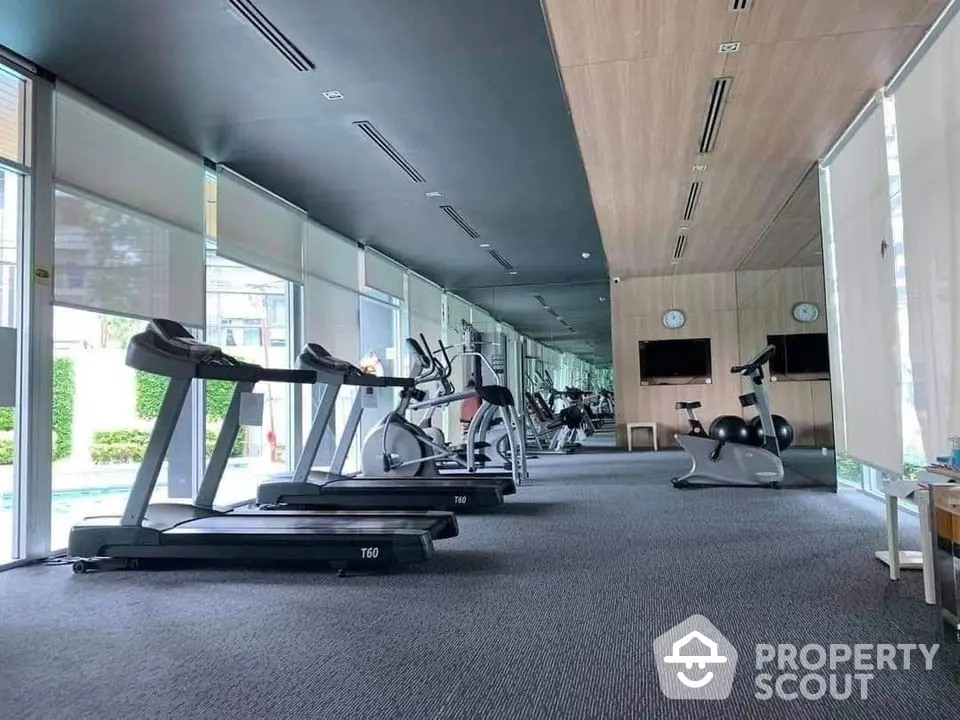 Spacious modern gym with state-of-the-art equipment and mirrored walls in luxury property.