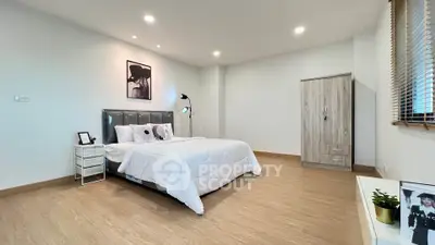 Spacious modern bedroom with stylish decor and ample natural light