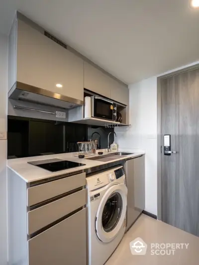 Modern compact kitchen with washing machine and sleek cabinetry