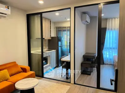 Modern apartment interior with open kitchen and cozy living area featuring stylish furniture.