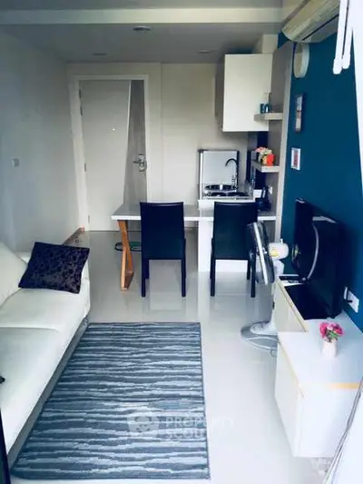 Modern compact living room with kitchenette, sleek furniture, and stylish decor