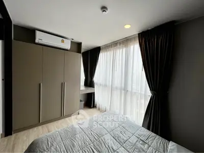 Modern bedroom with large window and sleek wardrobe in a stylish apartment.