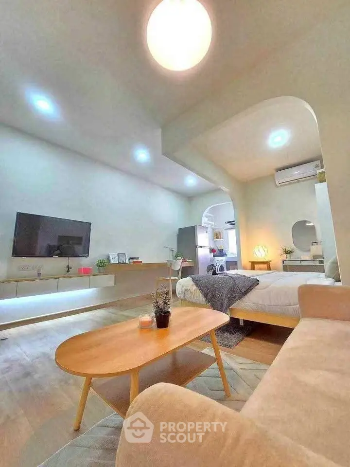 Modern living room with cozy seating and stylish decor in open layout apartment.