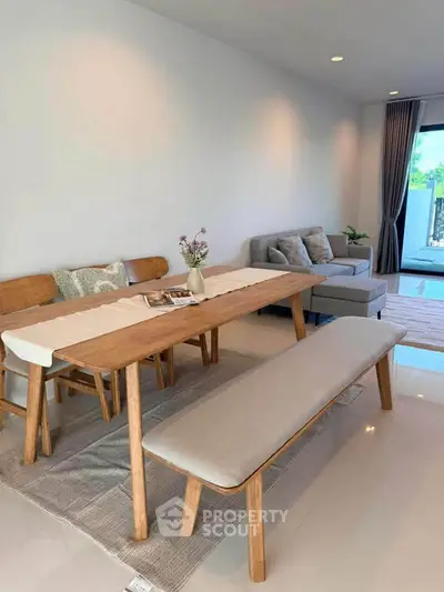 Modern living room with stylish wooden dining set and cozy seating area.