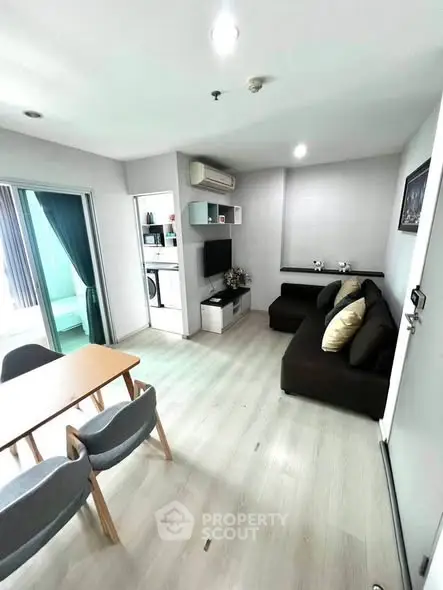 Modern living room with sleek furniture and open layout, featuring a cozy sofa and dining area.