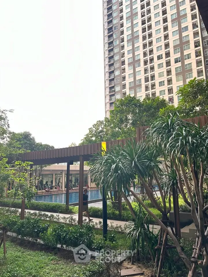 Luxurious condominium with lush garden and inviting pool area, perfect for relaxation and leisure.