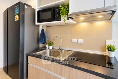 Modern kitchen with sleek appliances and stylish cabinetry in a contemporary apartment.