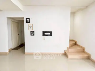 Spacious interior with modern staircase and wall-mounted TV setup, ideal for contemporary living.