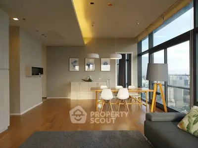 Modern living room with panoramic city view and stylish dining area.
