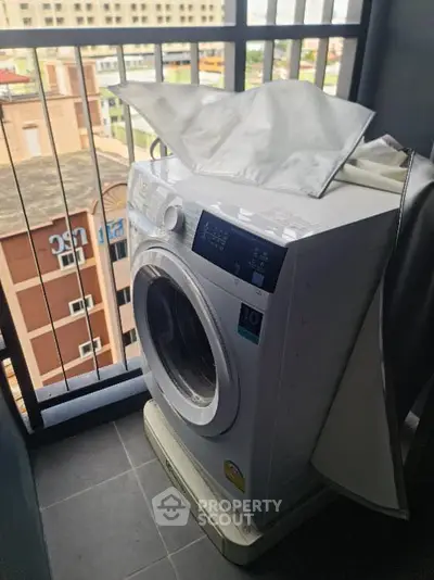 Modern washing machine on a balcony with city view, perfect for urban living convenience.