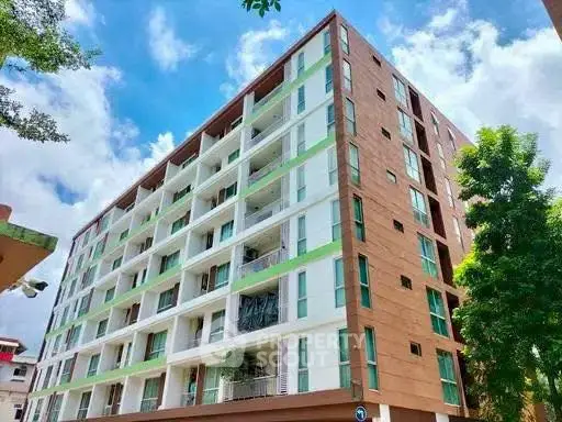 Modern multi-story apartment building with balconies and contemporary design.