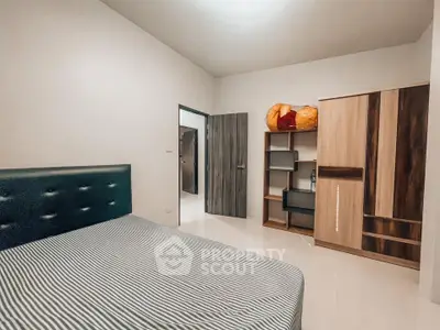 Spacious bedroom with modern furnishings and ample storage space.