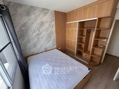 Modern bedroom with stylish wooden wardrobe and cozy bed in a well-lit space.