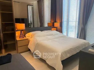 Modern bedroom with stylish decor and large windows offering natural light