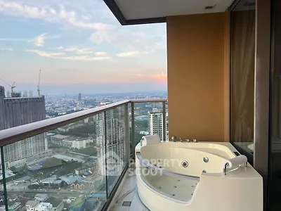 Luxurious high-rise balcony with jacuzzi offering stunning cityscape views at sunset.