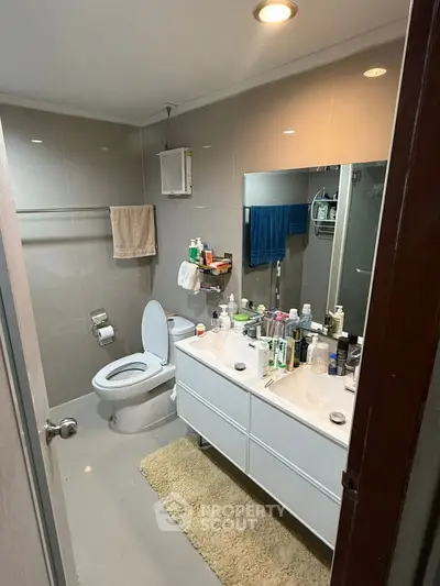 Modern bathroom with sleek vanity and ample storage in a contemporary home.