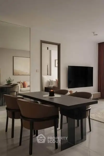 Elegant dining area with modern table and chairs, open layout to cozy living room with wall-mounted TV.