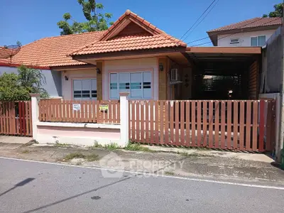Charming single-story house with tiled roof and fenced yard in a quiet neighborhood.