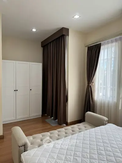 Cozy bedroom with elegant curtains and stylish white wardrobe