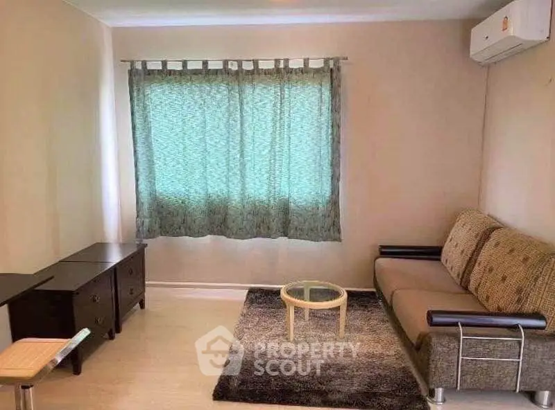 Cozy living room with modern sofa, air conditioning, and stylish decor.