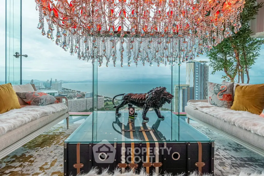 Luxurious living room with stunning ocean view, elegant chandelier, and stylish decor in high-rise apartment.