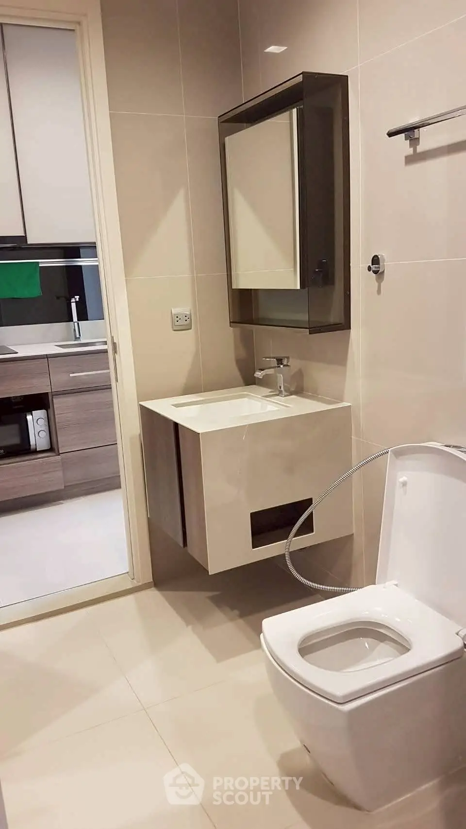 Modern bathroom with sleek fixtures and adjacent kitchen view