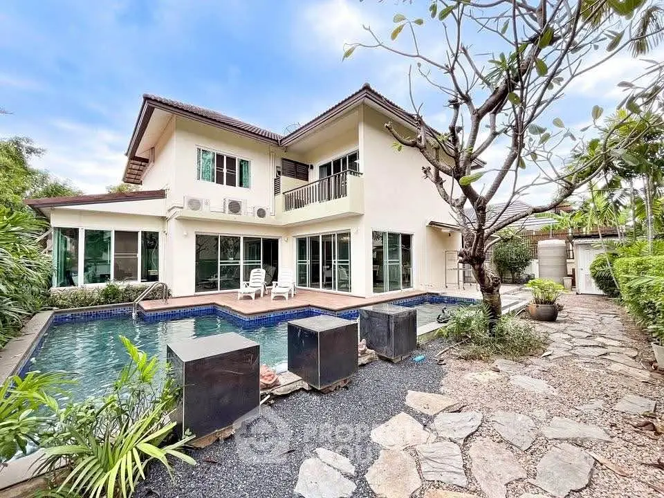 Stunning two-story home with private pool and lush garden, perfect for luxurious living.