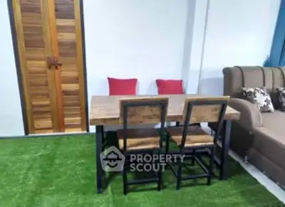 Charming living room with rustic wooden furniture and vibrant green carpet for a cozy ambiance.