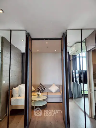 Modern living room with stylish decor and mirrored walls enhancing space