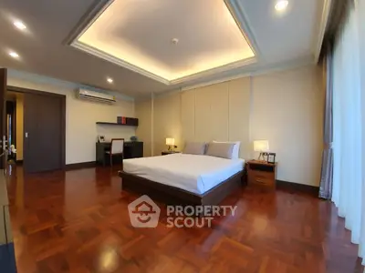 Spacious bedroom with elegant wooden flooring and modern decor