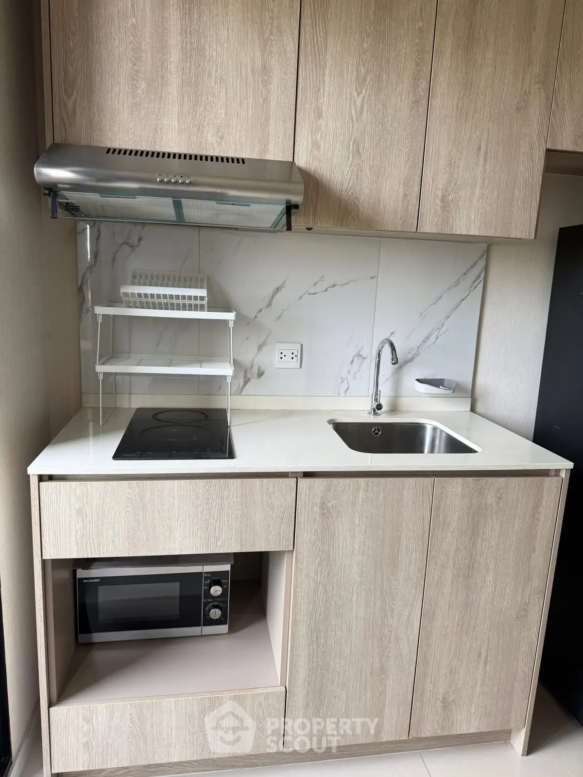 Modern compact kitchen with sleek wooden cabinets and built-in appliances