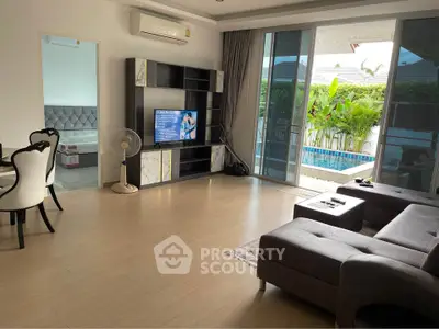 Spacious living room with modern furniture and pool view, perfect for relaxation and entertainment.