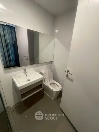 Modern bathroom with sleek design and white fixtures in a contemporary apartment.