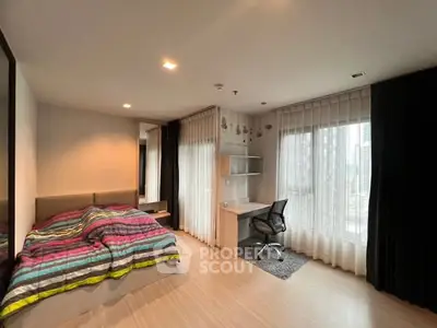 Modern bedroom with study area and city view, featuring stylish decor and ample natural light.