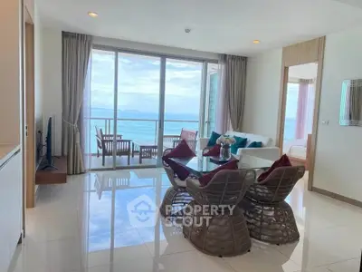Luxurious living room with ocean view and elegant dining area in beachfront apartment.