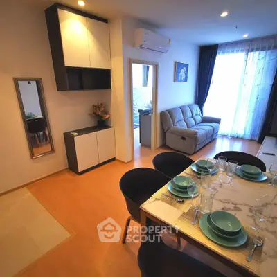 Modern living room with dining area, stylish furniture, and natural light from large windows.