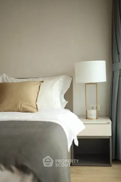 Elegant bedroom with modern lamp and cozy bedding, perfect for relaxation.