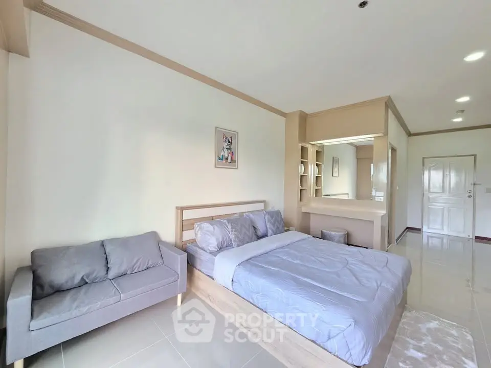 Spacious bedroom with modern decor and cozy seating area