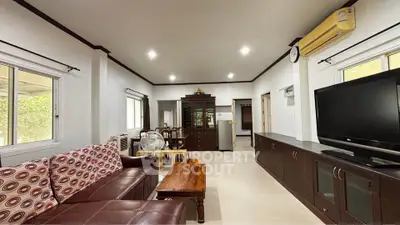 Spacious living room with modern furniture and large TV, perfect for family gatherings.