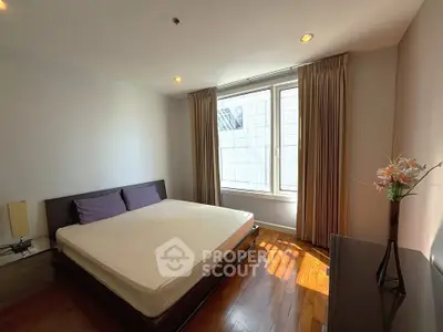 Spacious bedroom with large window and elegant decor in modern apartment